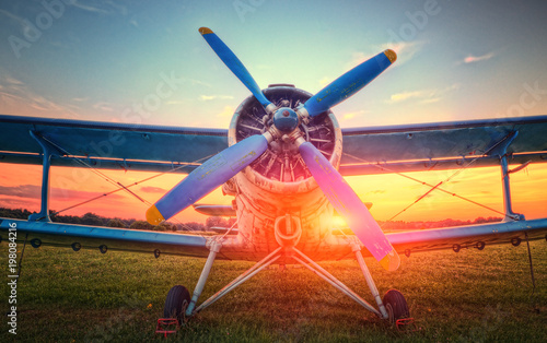 A view of a biplane at sunset