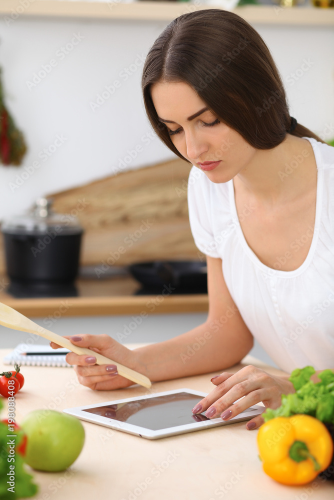 Beautiful Hispanic woman is making online shopping by tablet computer and credit card Beautiful Hispanic woman is making online shopping by tablet computer and credit card