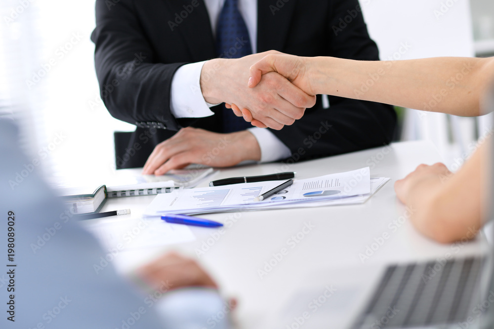 Close Up of unknown business people shaking hands while finishing up a meeting. Handshaking, agreement or success concept in people communication Close Up of unknown business people shaking hands while finishing up a meeting. Handshaking, agreement or success concept in people communication