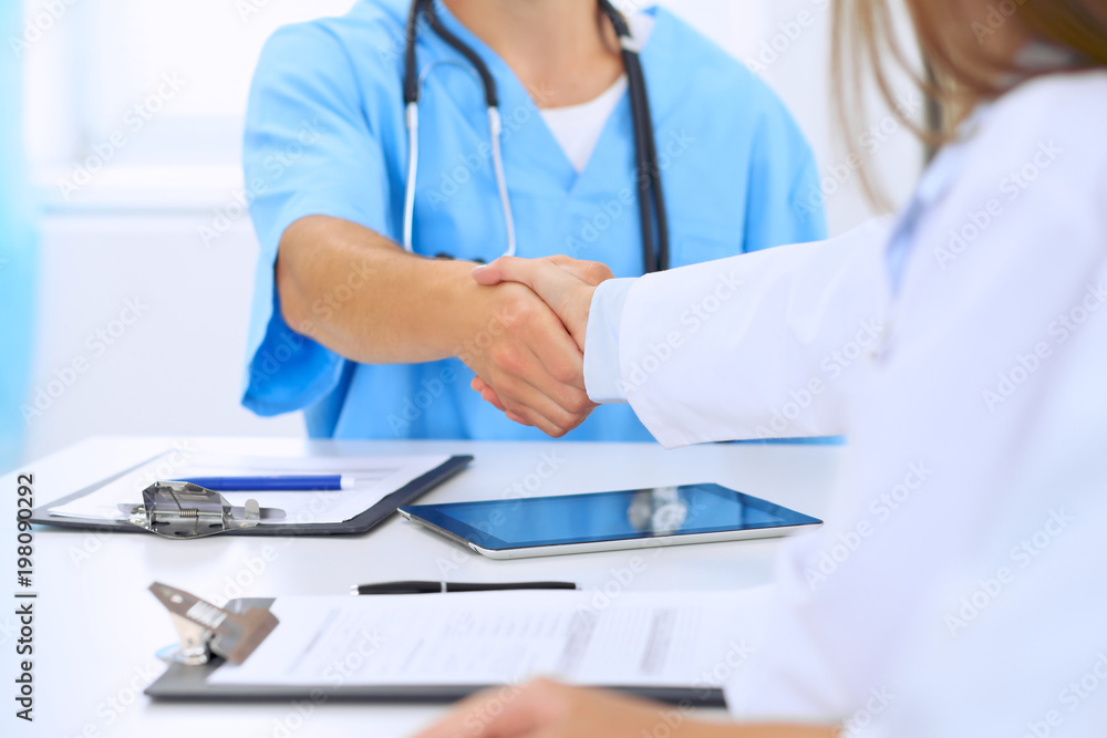 Doctors shaking hands to each other finishing up medical meeting Doctors shaking hands to each other finishing up medical meeting