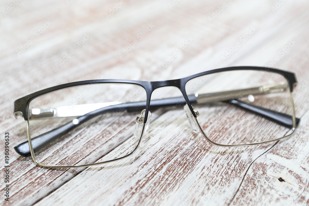 Fashionable men's eyeglass frame on white wooden background Fashionable men's eyeglass frame on white wooden background