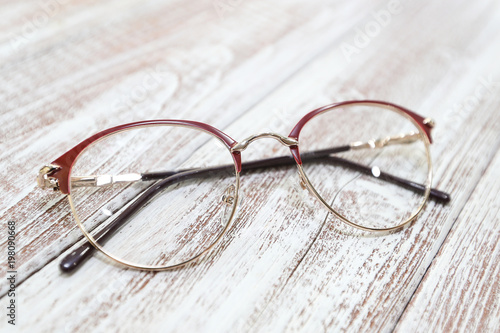Women's fashionable eyeglass frame on white wooden background