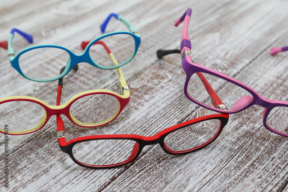 Kids colorful eyeglass frames on a light wooden background Kids colorful eyeglass frames on a light wooden background