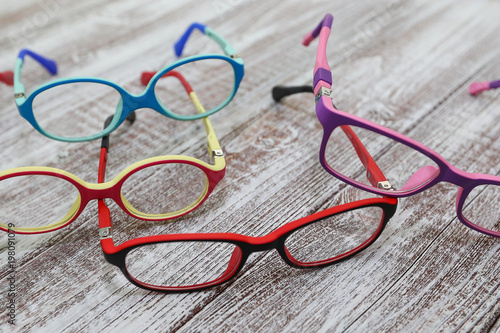 Kids colorful eyeglass frames on a light wooden background