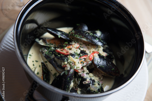 Stewed mussels with vegetables in a saucepan