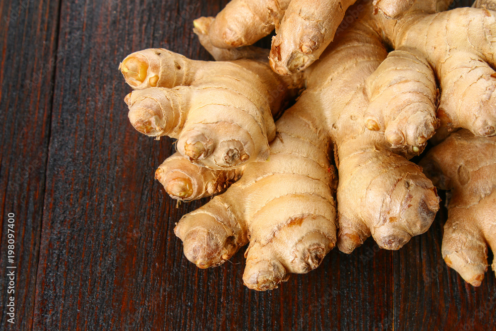 Spicy root of ginger on a wooden table.