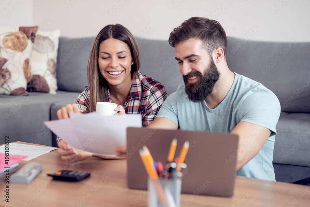 Young couple calculating bills at home Young couple calculating bills at home