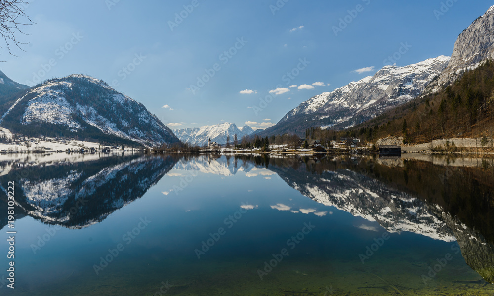 Sunny winter Alpine lake Grundlsee (Styria, Austria) with fantastic reflection on the water surface.