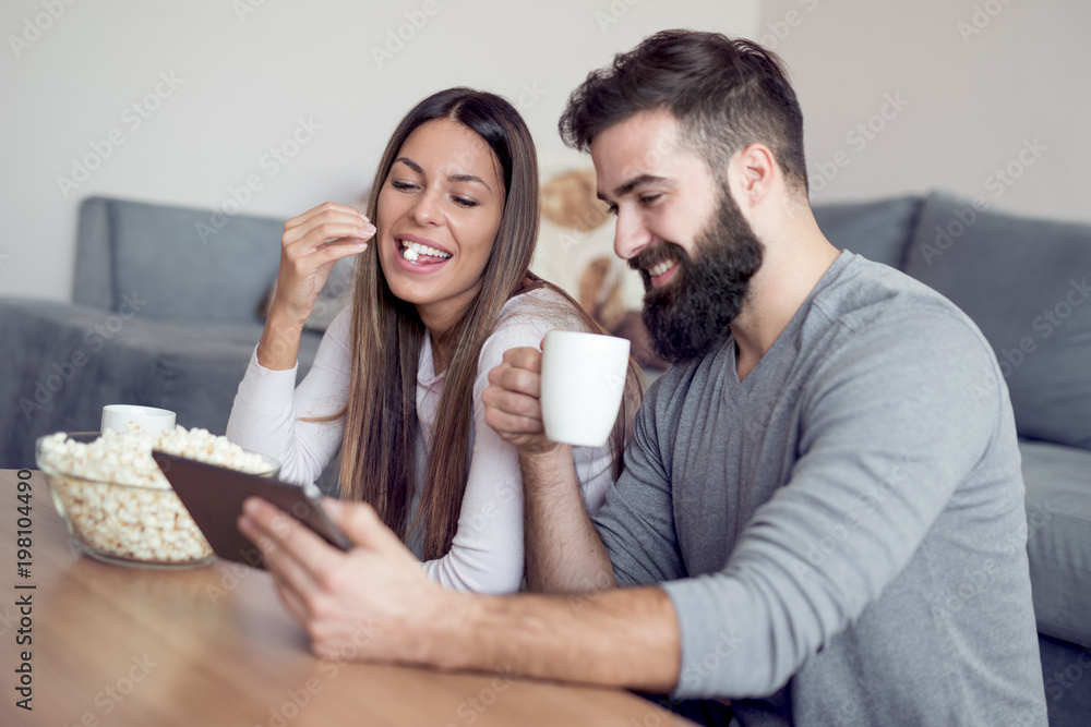 Cheerful couple using digital tablet at home Cheerful couple using digital tablet at home