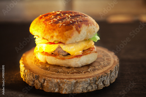 homemade burger on wooden board. Sunset light