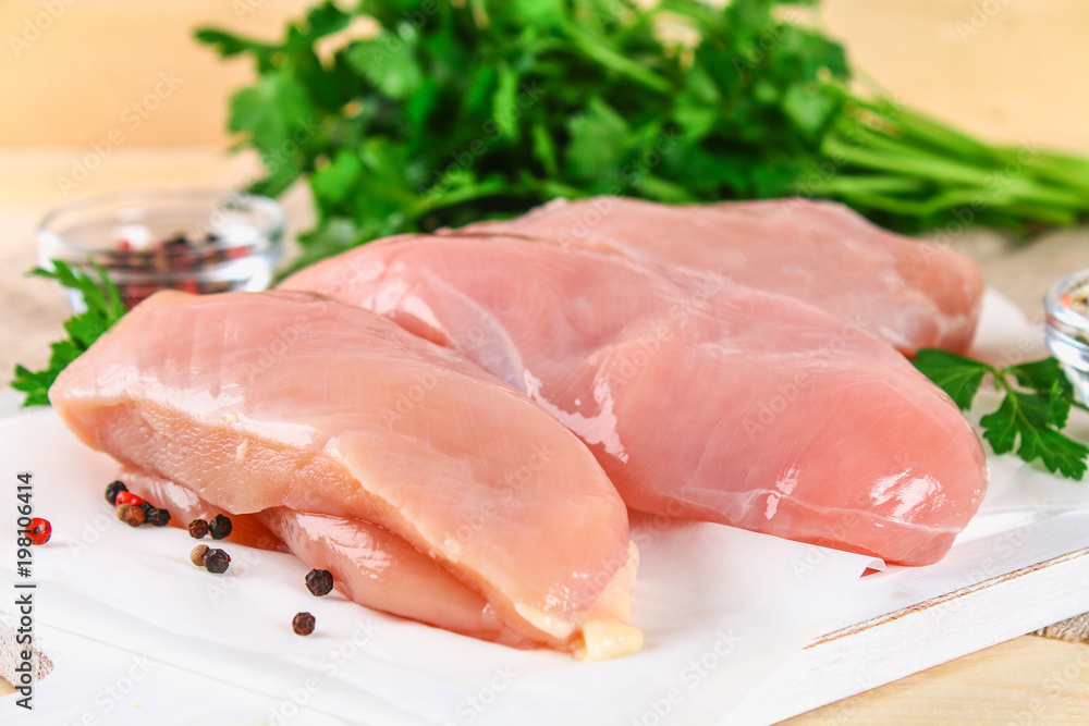 raw chicken fillets on wooden cutting board. raw chicken fillets on wooden cutting board.