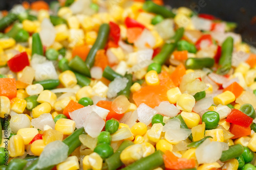 Fresh vegetables in a frying pan. Fresh vegetable products, freshly frozen odietic vegetables, broccoli, corn, asparagus, pepper, carrots are cooked in a frying pan on a gas stove.