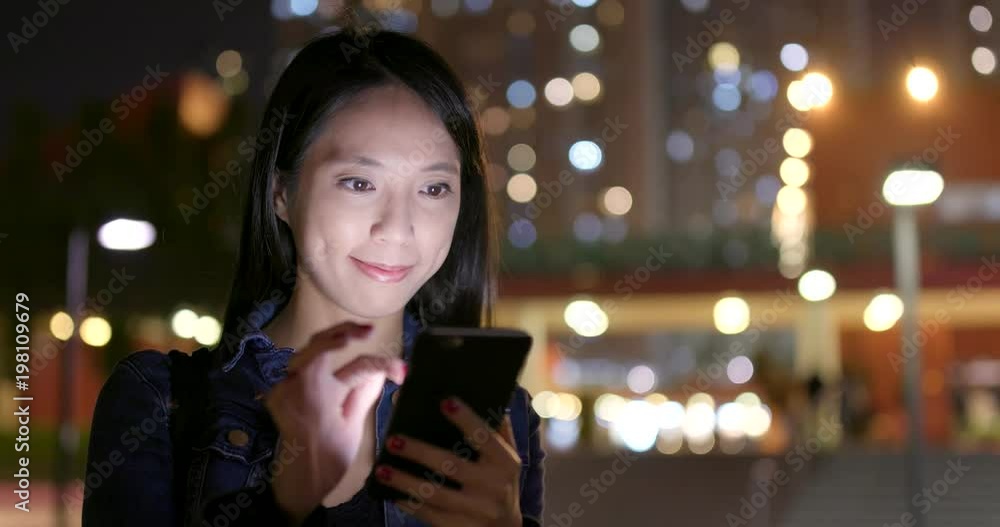 Woman use of mobile phone in city at night Woman use of mobile phone in city at night