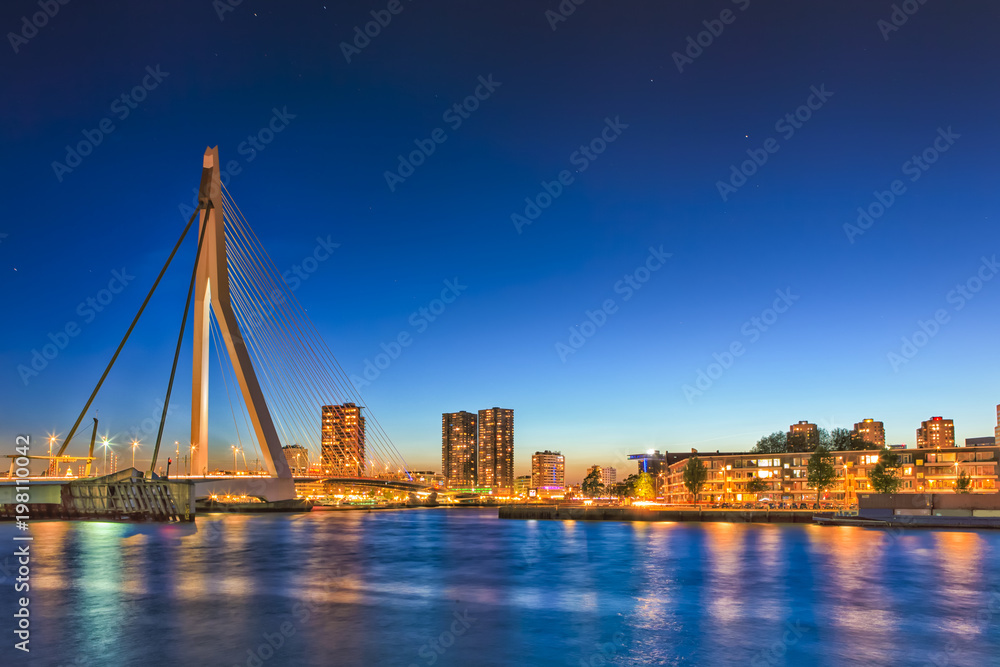 Travel Concepts. View of Unique and Beautiful Erasmus Bridge in Rotterdam. City Scyline on the Background. Shot Made During Blue Hour.