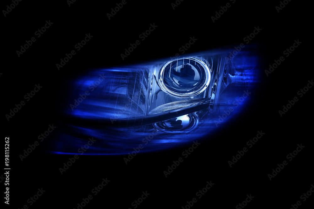 Modern automotive headlight on a black background shine blue light.