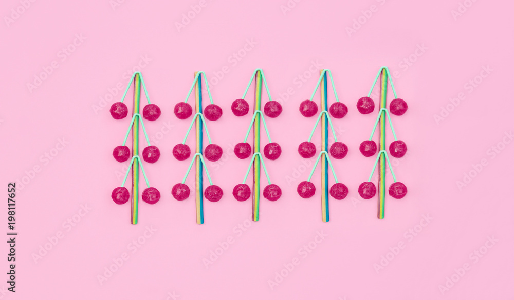 Assorted colored lollipops on pink background.