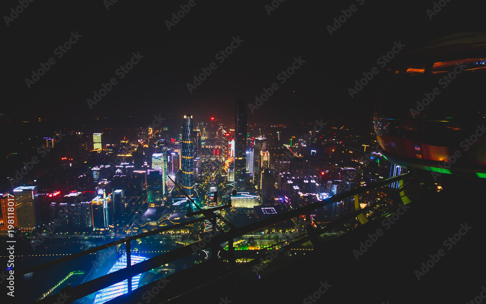 Beautiful wide-angle night aerial view of Guangzhou Zhujiang New Town financial district, Guangdong, China with skyline and scenery beyond the city, seen from the observation deck of Canton Tower
