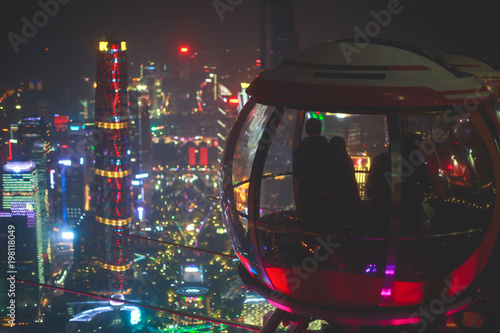 Beautiful wide-angle night aerial view of Guangzhou Zhujiang New Town financial district, Guangdong, China with skyline and scenery beyond the city, seen from the observation deck of Canton Tower 