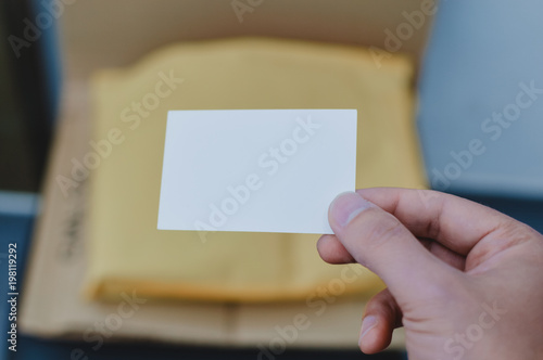 Closeup on hand with letter craft envelope on the background. Receiving and sending commercial or personal package, top view communication conceptual design