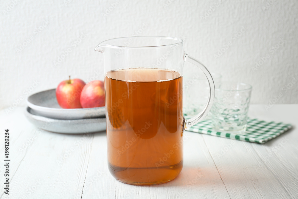 Jug with fresh apple juice on wooden table Jug with fresh apple juice on wooden table