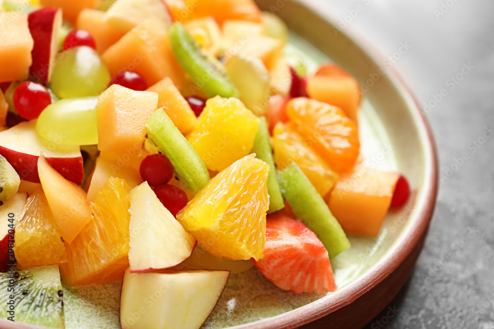 Plate with fresh cut fruits on table, closeup Plate with fresh cut fruits on table, closeup