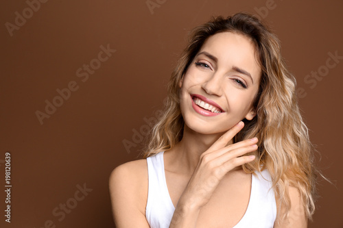 Young woman with beautiful smile on color background. Teeth whitening