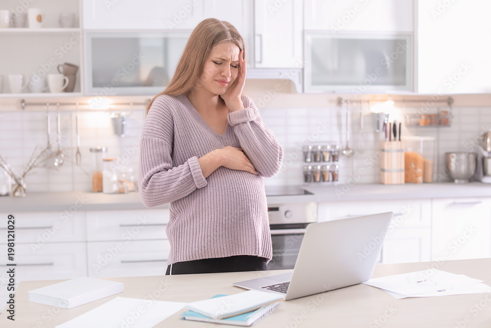 Young pregnant woman suffering from headache in home office Young pregnant woman suffering from headache in home office