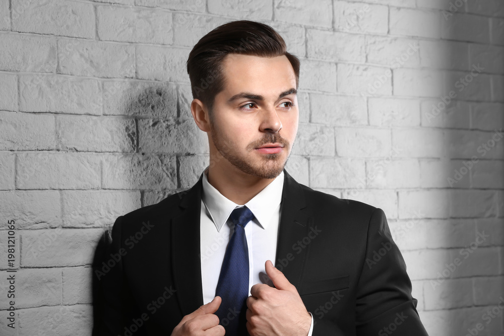 Portrait of young man with beautiful hair on brick wall background Portrait of young man with beautiful hair on brick wall background
