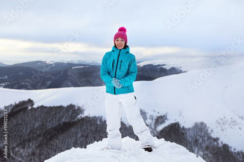 Happy woman on snowy mounta...