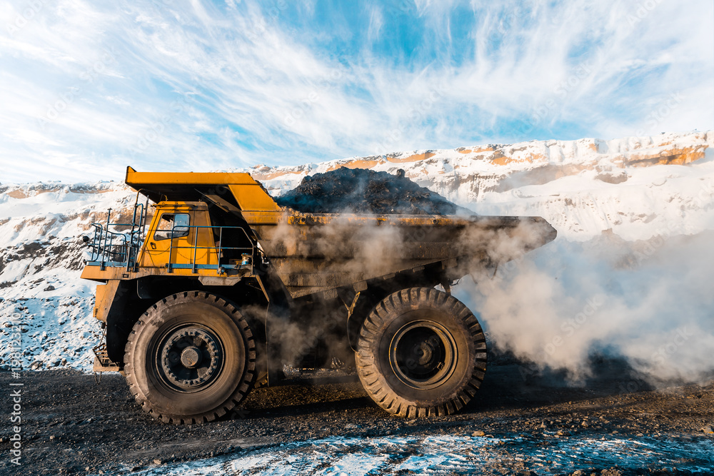 Obraz premium Large quarry dump truck. Loading the rock in dumper. Loading coal into body truck. Production useful minerals. Mining truck mining machinery, to transport coal from open-pit as the Coal Production