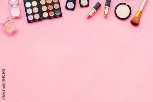 Decorative cosmetics for make up on pink desk background top view mock up