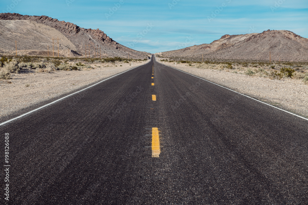 Empty scenic long straight desert road with yellow marking lines Empty scenic long straight desert road with yellow marking lines