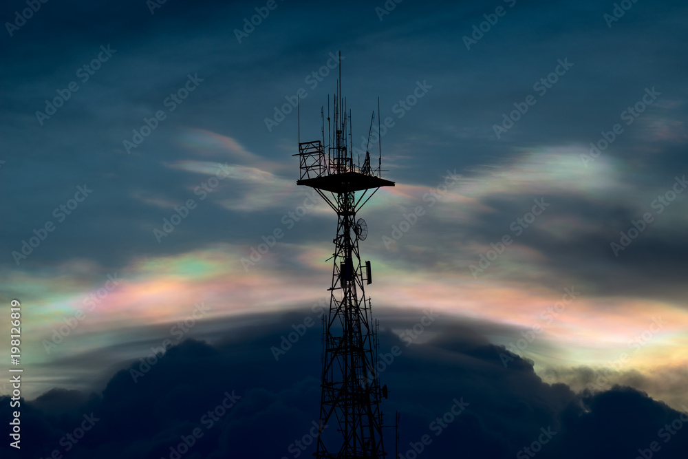 Silhouette of cellular tower with beautiful sunset cloudy sky