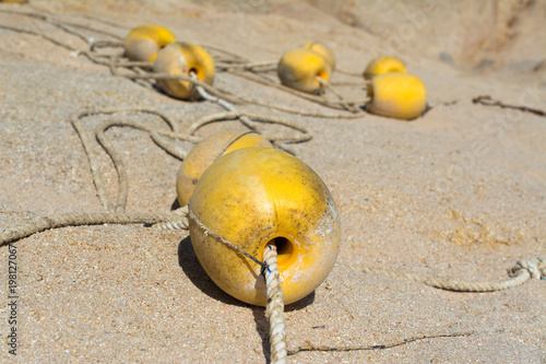 Las boyas amarillas están en la arena de la playa.