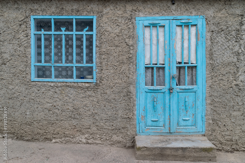 A traditional clay based house with blue window and door in Tocuz, Moldova A traditional clay based house with blue window and door in Tocuz, Moldova