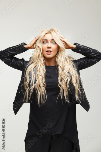 Photos stressful woman in panic with big eyes in horror, holding his hands on his head, learns the awful news or trouble, can not believe