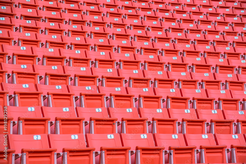 Many orange chairs in football stadium.