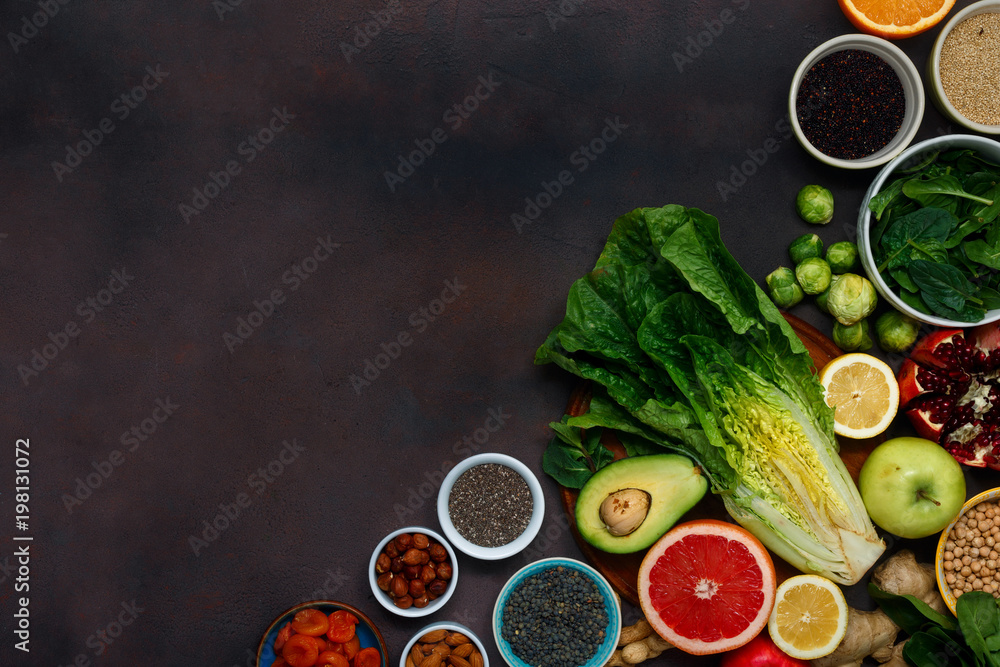 Set vegetarian healthy food - different vegetables and fruits, superfood, seeds, cereal, leaf vegetable on dark background with copy space, top view. Flat lay. Clean eating concept