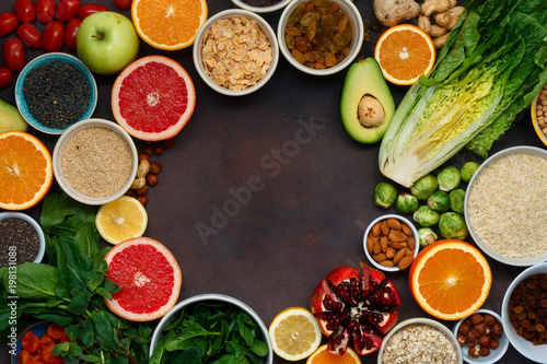 Clean eating concept. Frame of vegetarian healthy food - different vegetables and fruits, superfood, seeds, cereal, leaf vegetable on dark background, top view. Flat lay