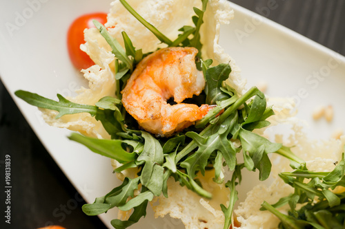 fried prown with herbs on the table. dish with raw shrims, herbs and tomatoes photo