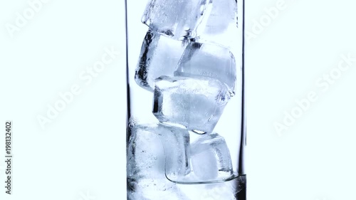 Close-up timelapse of melting ice cubes in a small glass