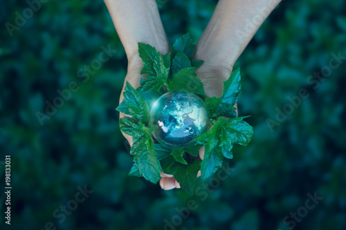 Fototapeta Naklejka Na Ścianę i Meble -  Earth day, Saving energy concept, Hand holding earth on green leaf against nature in green park. Save the earth and Ecological, Element of this image furnished by NASA.