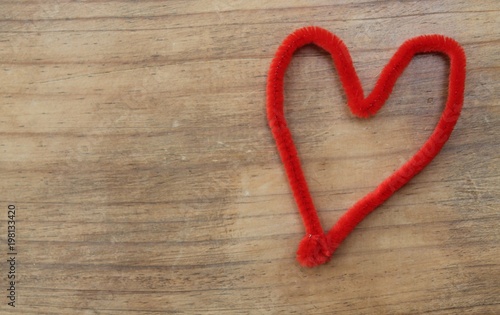 Red craft pipe cleaner shaped as a heart.