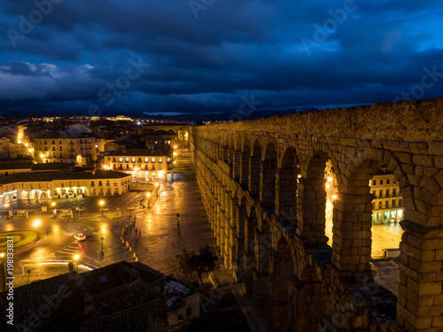 Nightly Segovia, Spain at the ancient Roman aqueduct. The Aqueduct of Segovia, located in Plaza del Azoguejo, is the defining historical feature of the city.