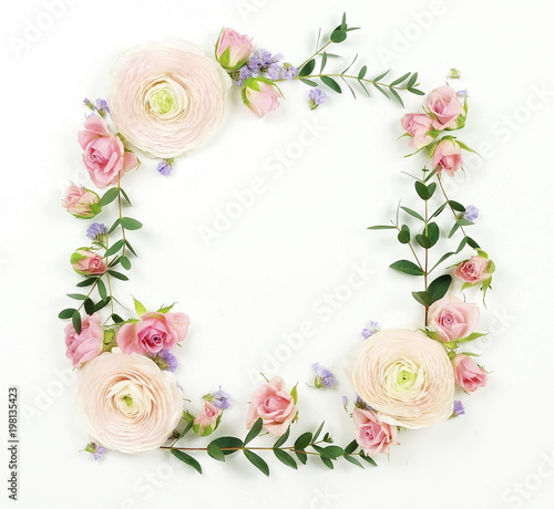 Flowers background. Wreath frame made of pale pink roses and ranunculus flowers and eucalyptus branches on a white background. Flat lay. top view. copy space