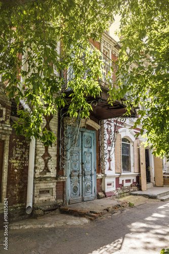 Fototapeta Naklejka Na Ścianę i Meble -  Facade of the 19th century crumbling house on Sovetskaya street in the center of Kurgan, Russia.
