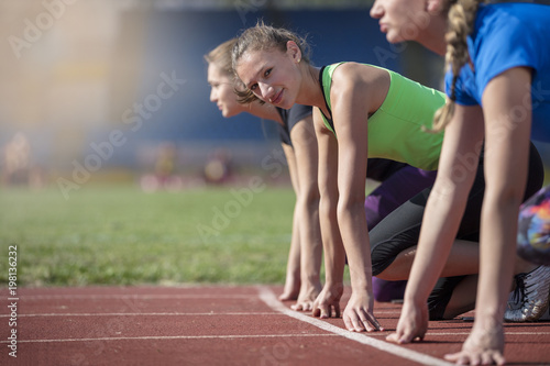 Women ready to race on track field photo