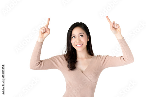 Smiling young beautiful Asian woman looking and pointing her hands up