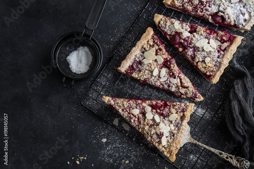 cherry and almond streusel tart, black background