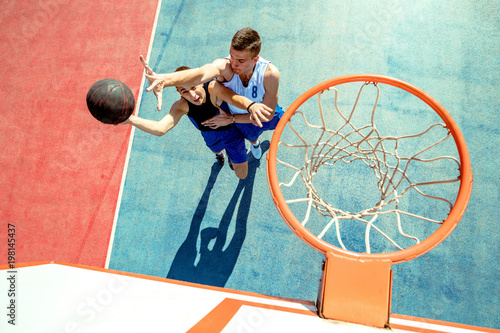 High angle view of basketball player dunking basketball in hoop photo